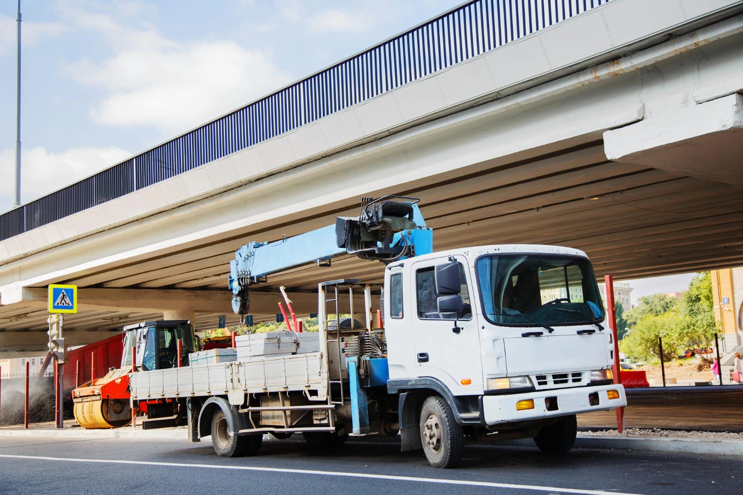 รถเฮี๊ยบขณะกำลังยกวัสดุก่อสร้างเพื่อเตรียมการขนส่ง